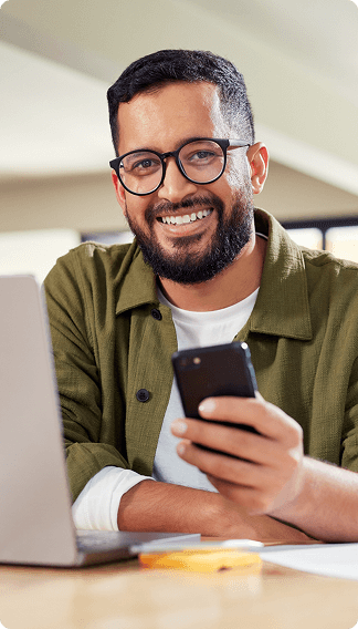 Smiling man with glasses holding phone